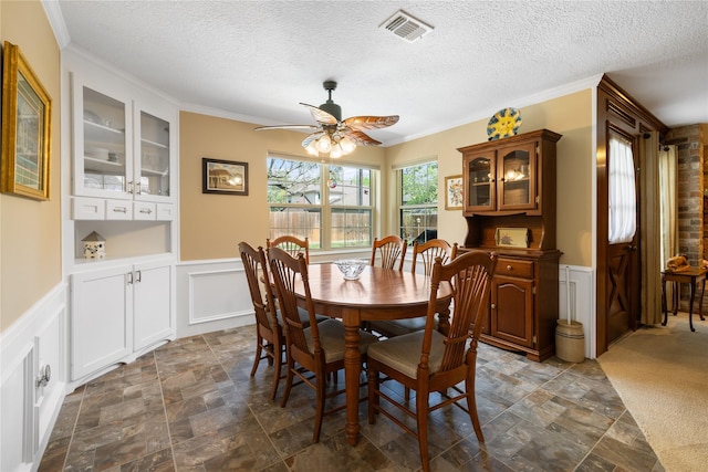 dining space with stone finish floor, a ceiling fan, a textured ceiling, and visible vents