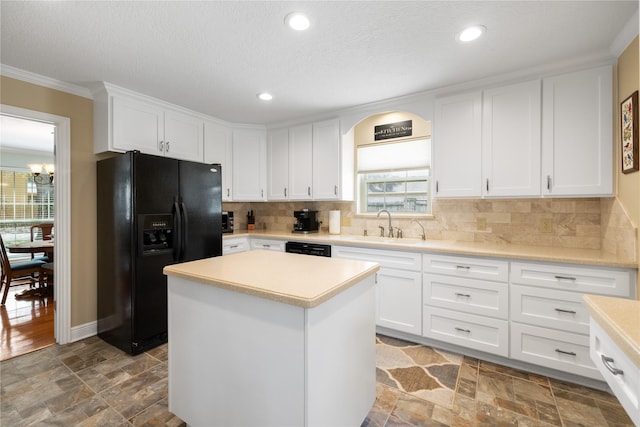 kitchen with a sink, black appliances, stone finish floor, and light countertops