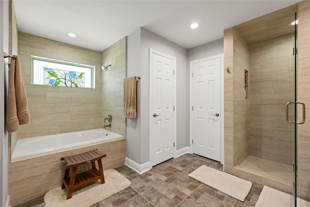 full bathroom featuring baseboards, stone tile floors, and recessed lighting