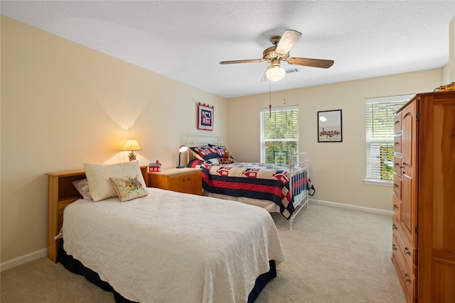 bedroom with baseboards, ceiling fan, and light carpet