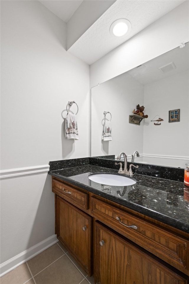 bathroom with tile patterned floors, baseboards, and vanity