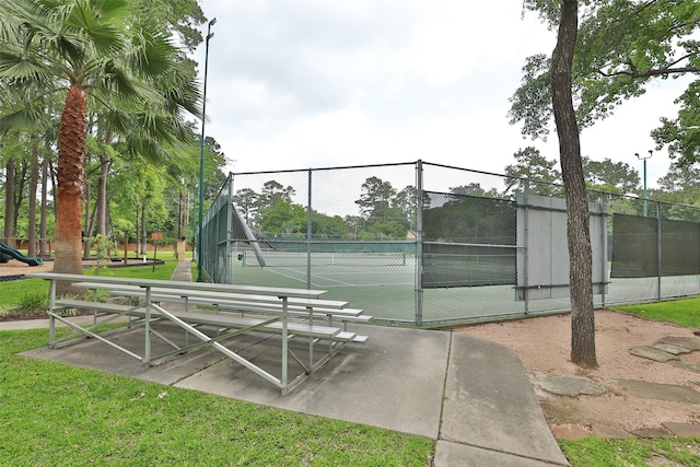 view of home's community featuring fence, a yard, and a tennis court
