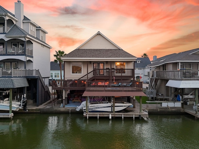 dock area featuring a deck with water view, boat lift, and stairs