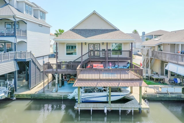 view of dock with boat lift, stairway, a patio area, and a water view