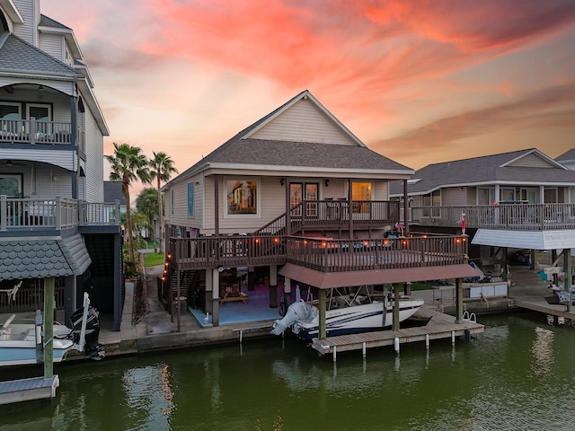view of dock featuring a deck with water view, boat lift, and a patio area
