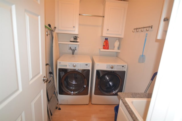 4031 Hardin Dr, Galveston, TX 77554 - laundry area featuring washing machine and dryer, light wood-type flooring, a sink, and cabinet space