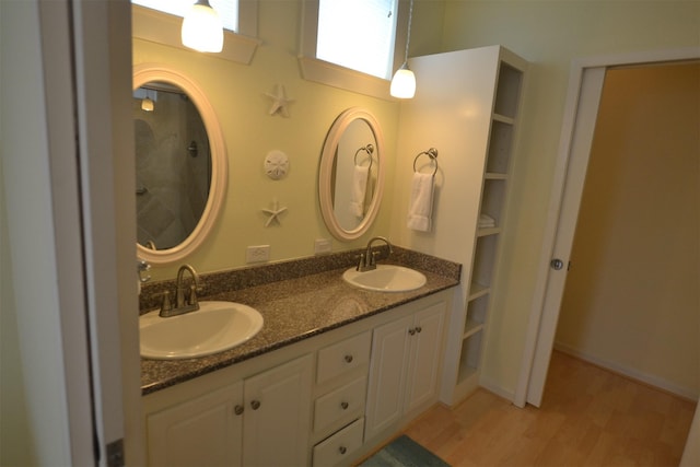 4031 Hardin Dr, Galveston, TX 77554 - full bathroom featuring wood finished floors, double vanity, and a sink