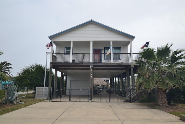 4031 Hardin Dr, Galveston, TX 77554 - view of front of home with a garage, a porch, a carport, a gate, and concrete driveway