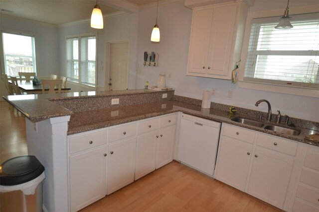 4031 Hardin Dr, Galveston, TX 77554 - kitchen featuring a peninsula, crown molding, light wood-style floors, white dishwasher, and a sink