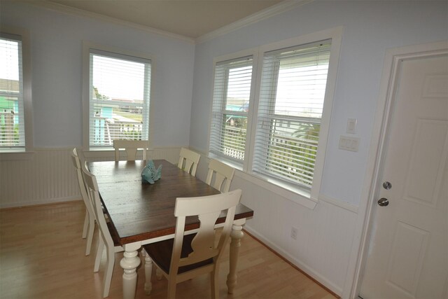 4031 Hardin Dr, Galveston, TX 77554 - dining area with light wood-style floors, ornamental molding, and wainscoting