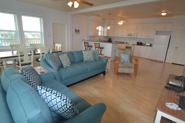 4031 Hardin Dr, Galveston, TX 77554 - living area with crown molding, a ceiling fan, and light wood finished floors