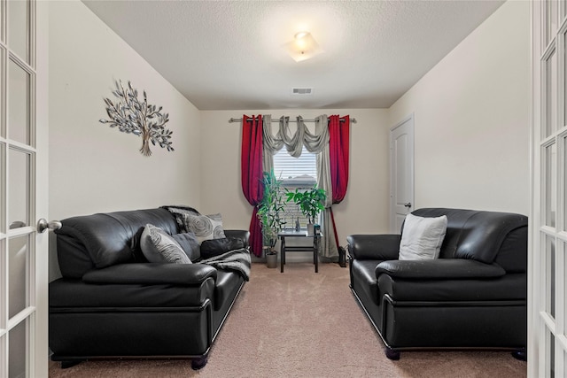 carpeted living room featuring visible vents and a textured ceiling
