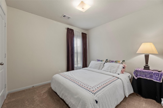 carpeted bedroom featuring baseboards and visible vents