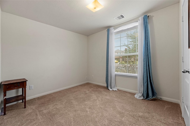 spare room featuring visible vents, carpet flooring, and baseboards