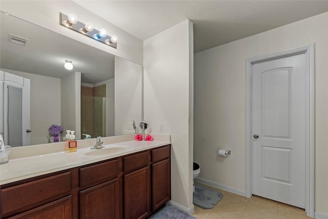 full bathroom with vanity, visible vents, a tile shower, tile patterned flooring, and toilet