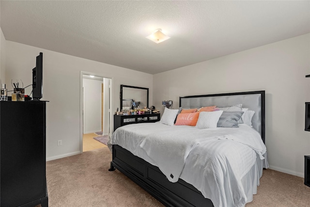 bedroom featuring light colored carpet, a textured ceiling, and baseboards