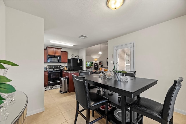 dining space featuring light tile patterned flooring, visible vents, a textured ceiling, and baseboards