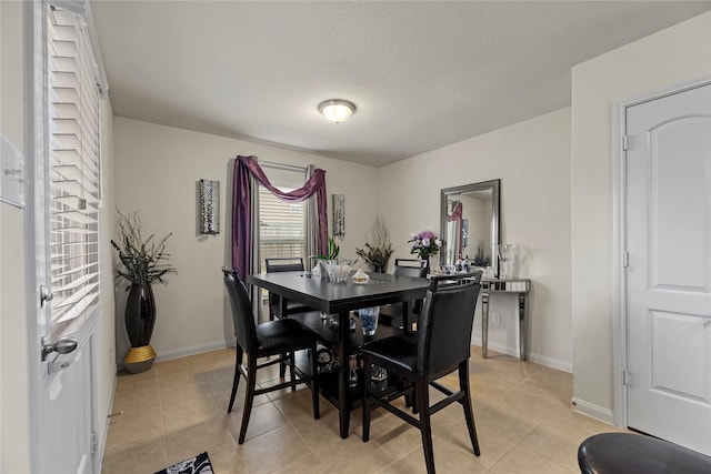 dining area featuring light tile patterned floors and baseboards