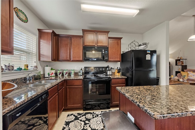kitchen featuring hanging light fixtures, black appliances, dark stone countertops, and a sink