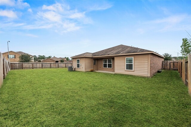 back of property featuring a yard, a fenced backyard, and cooling unit