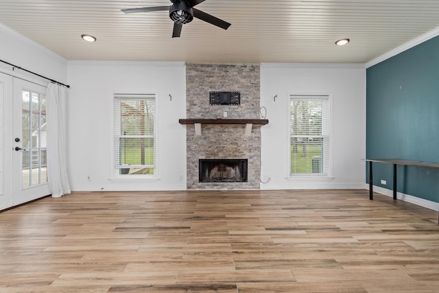 446 Piney Point Dr, Sour Lake, TX 77659 - unfurnished living room with a healthy amount of sunlight, a stone fireplace, ornamental molding, and light wood finished floors