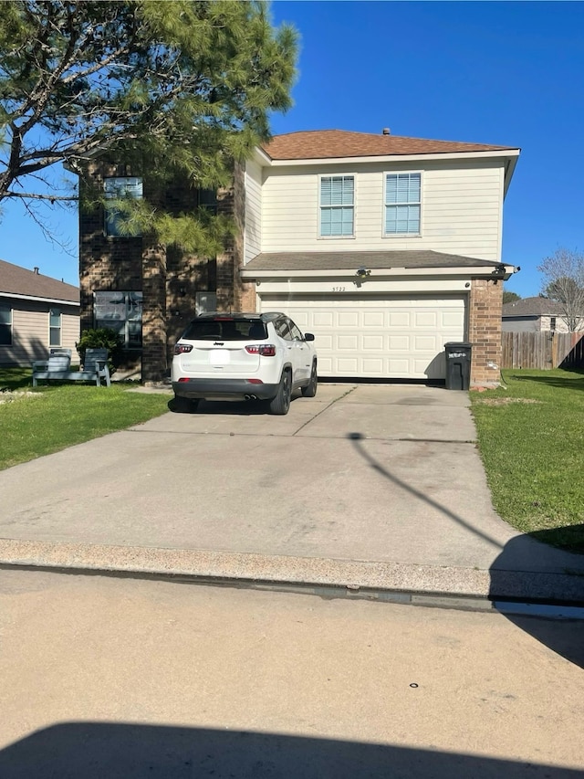 traditional-style house with driveway, a front lawn, a garage, and fence