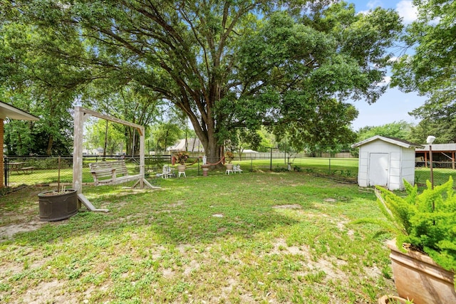 view of yard featuring an outbuilding, a fenced backyard, and a storage shed