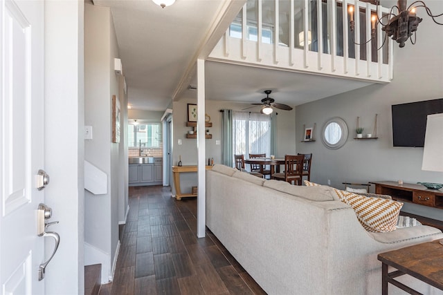 908 Calico Jack Cv, Galveston, TX 77554 - living room featuring dark wood-style flooring, a ceiling fan, a chandelier, and baseboards
