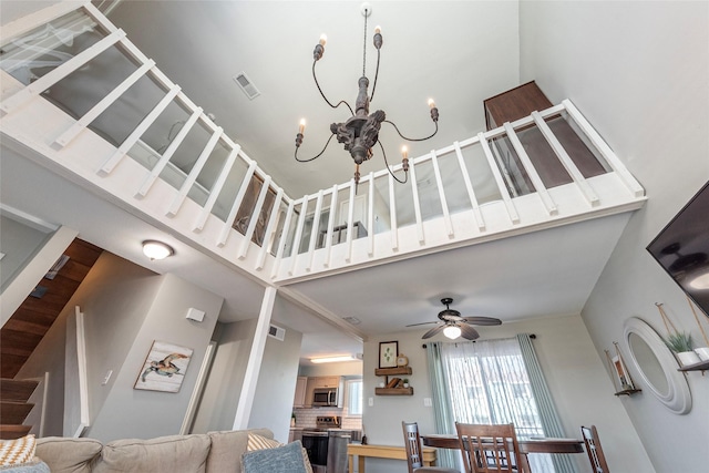 908 Calico Jack Cv, Galveston, TX 77554 - living room featuring a high ceiling, a chandelier, stairs, and a ceiling fan