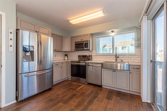 908 Calico Jack Cv, Galveston, TX 77554 - kitchen with stainless steel appliances, dark wood-type flooring, light countertops, a sink, and backsplash