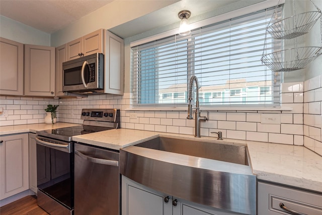 908 Calico Jack Cv, Galveston, TX 77554 - kitchen with appliances with stainless steel finishes, a sink, decorative backsplash, and plenty of natural light