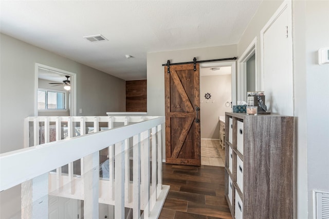908 Calico Jack Cv, Galveston, TX 77554 - hall featuring a barn door and dark wood-style floors