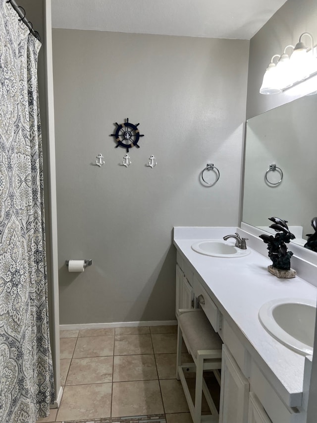 908 Calico Jack Cv, Galveston, TX 77554 - full bathroom featuring double vanity, tile patterned flooring, and baseboards