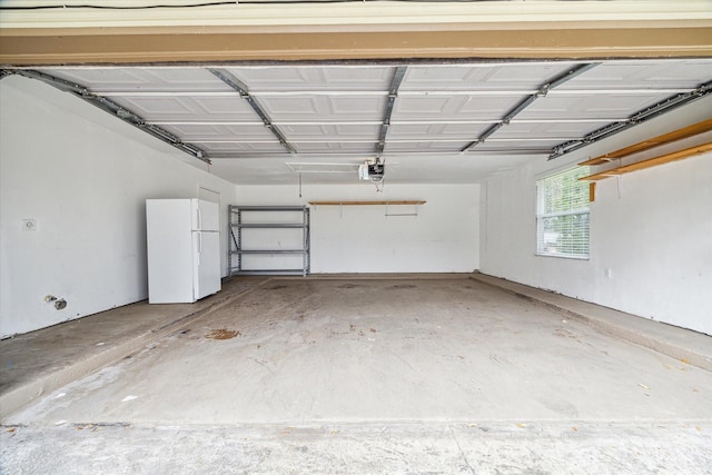 12007 Fairpoint Dr, Houston, TX 77099 - garage featuring a garage door opener and freestanding refrigerator