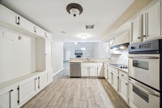 12007 Fairpoint Dr, Houston, TX 77099 - kitchen with visible vents, wood tiled floor, a peninsula, a sink, and appliances with stainless steel finishes