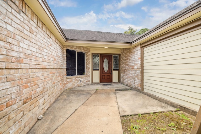 12007 Fairpoint Dr, Houston, TX 77099 - view of exterior entry featuring brick siding and roof with shingles