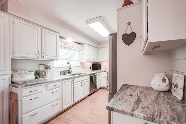 1818 Tiki Dr, Galveston, TX 77554 - kitchen featuring a sink, dishwasher, white cabinetry, crown molding, and light wood-style flooring