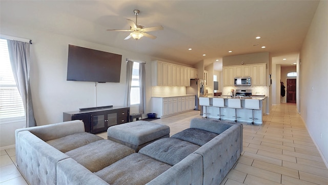 living area with a ceiling fan, baseboards, and recessed lighting