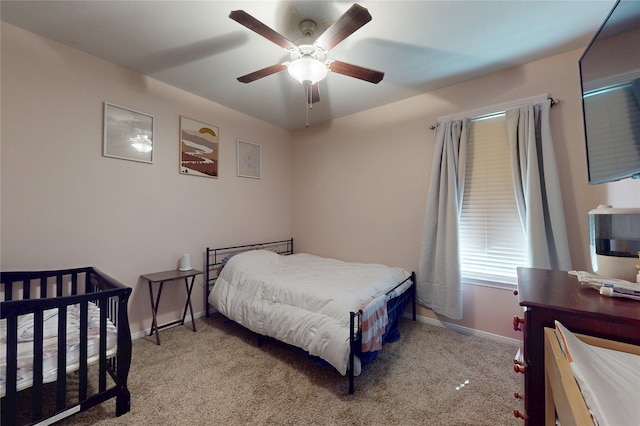 carpeted bedroom with a ceiling fan and baseboards