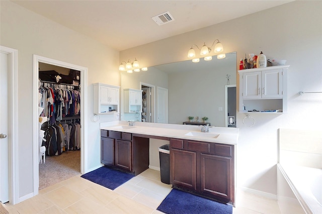 bathroom with double vanity, visible vents, a sink, and a spacious closet