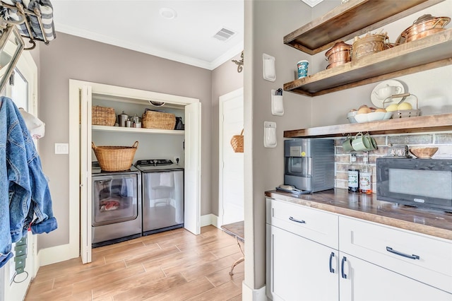719 Tarpaulin Way, Crosby, TX 77532 - kitchen with visible vents, open shelves, crown molding, black microwave, and separate washer and dryer