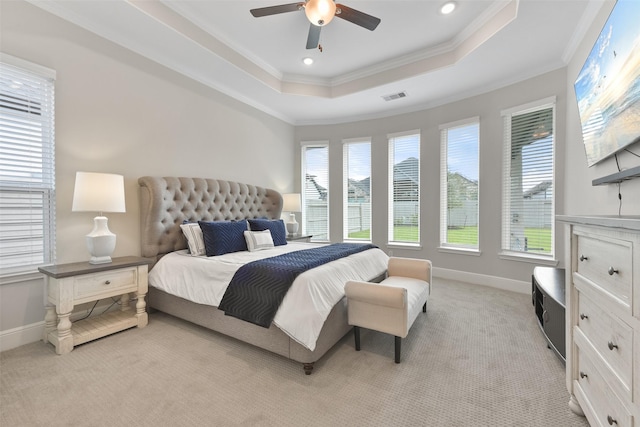 bedroom featuring visible vents, a raised ceiling, multiple windows, and light colored carpet