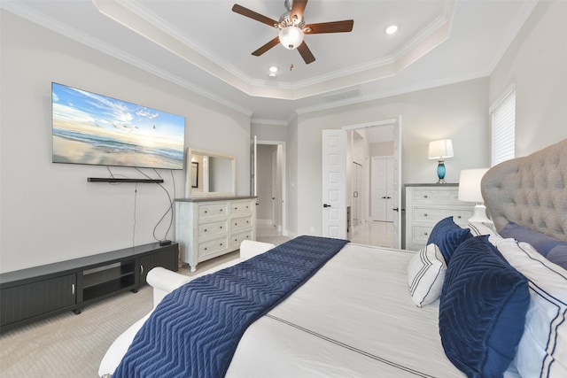 bedroom with light carpet, visible vents, a tray ceiling, and ornamental molding