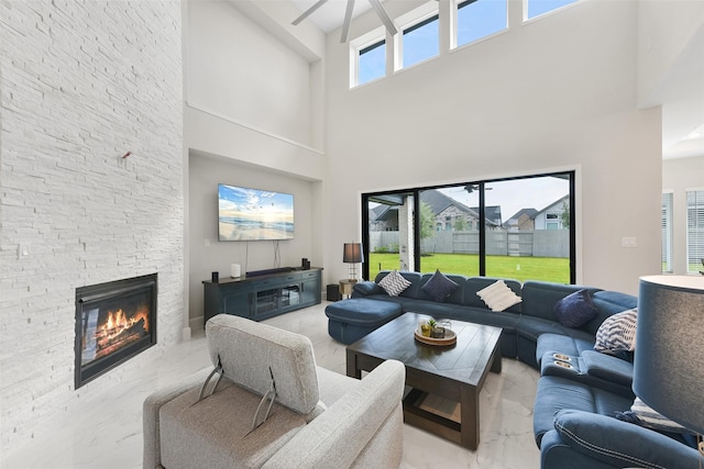 living room featuring marble finish floor, a fireplace, and ceiling fan