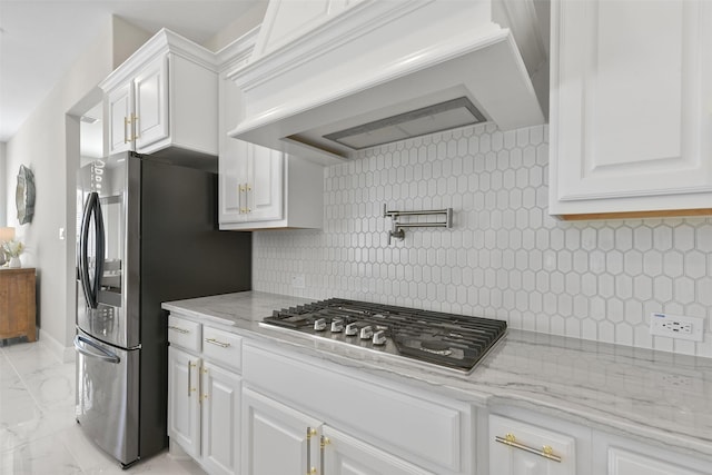 kitchen with light stone countertops, custom exhaust hood, stainless steel appliances, white cabinetry, and marble finish floor