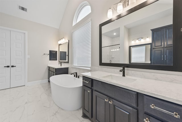 full bath with visible vents, marble finish floor, a sink, a tile shower, and lofted ceiling