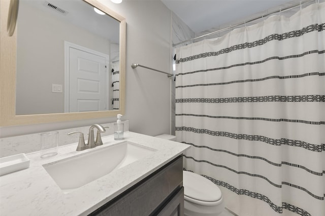 full bathroom featuring a shower with shower curtain, visible vents, toilet, and vanity