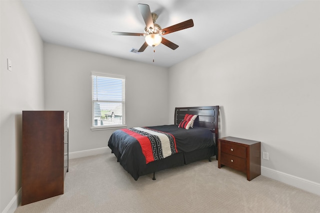 bedroom featuring baseboards, light carpet, and a ceiling fan