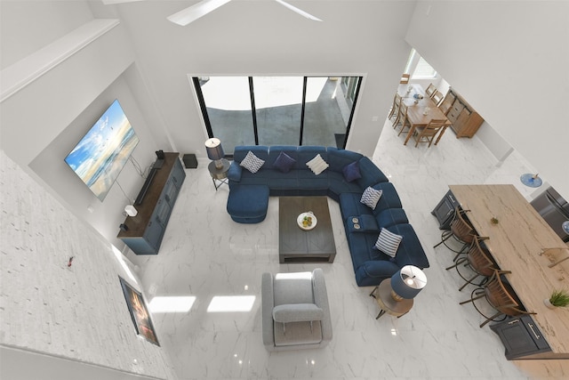 unfurnished living room with marble finish floor and a towering ceiling