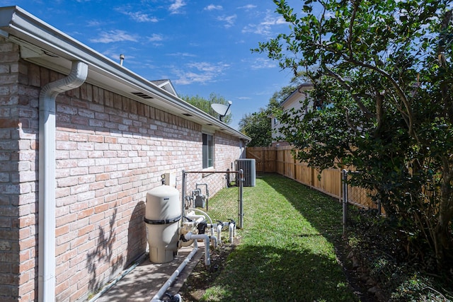 view of yard featuring central AC and fence